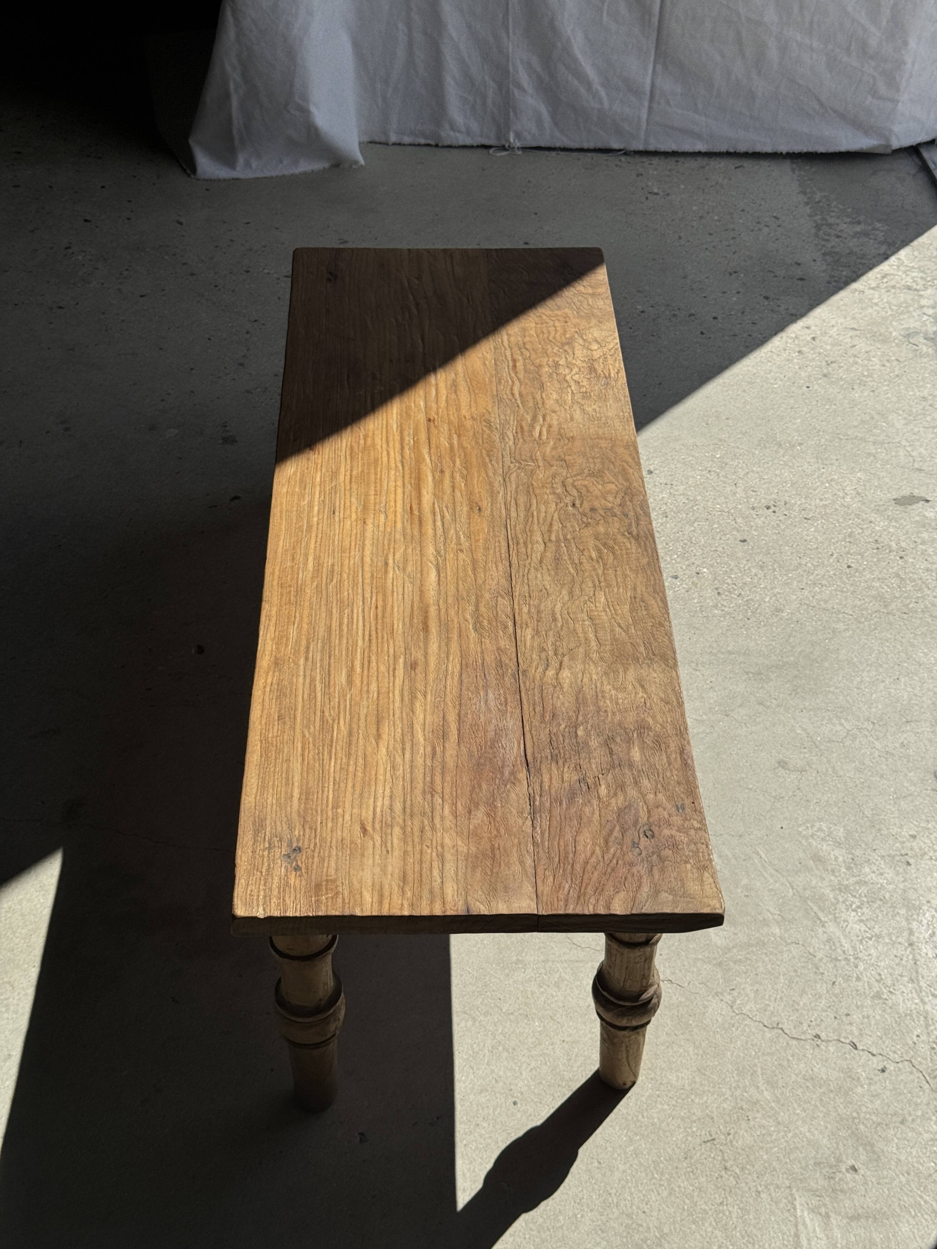 Brown Indonesian teak coffee table, with a border and cylindrical legs H40 L103.