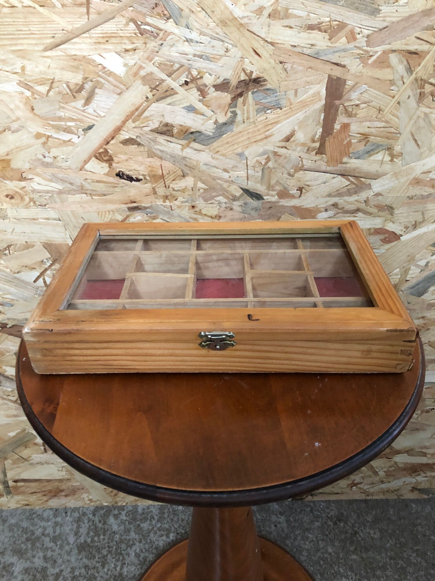 Old hanging display case with 15 wooden boxes, red background + vintage glass door