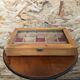 Old hanging display case with 15 wooden boxes, red background + vintage glass door