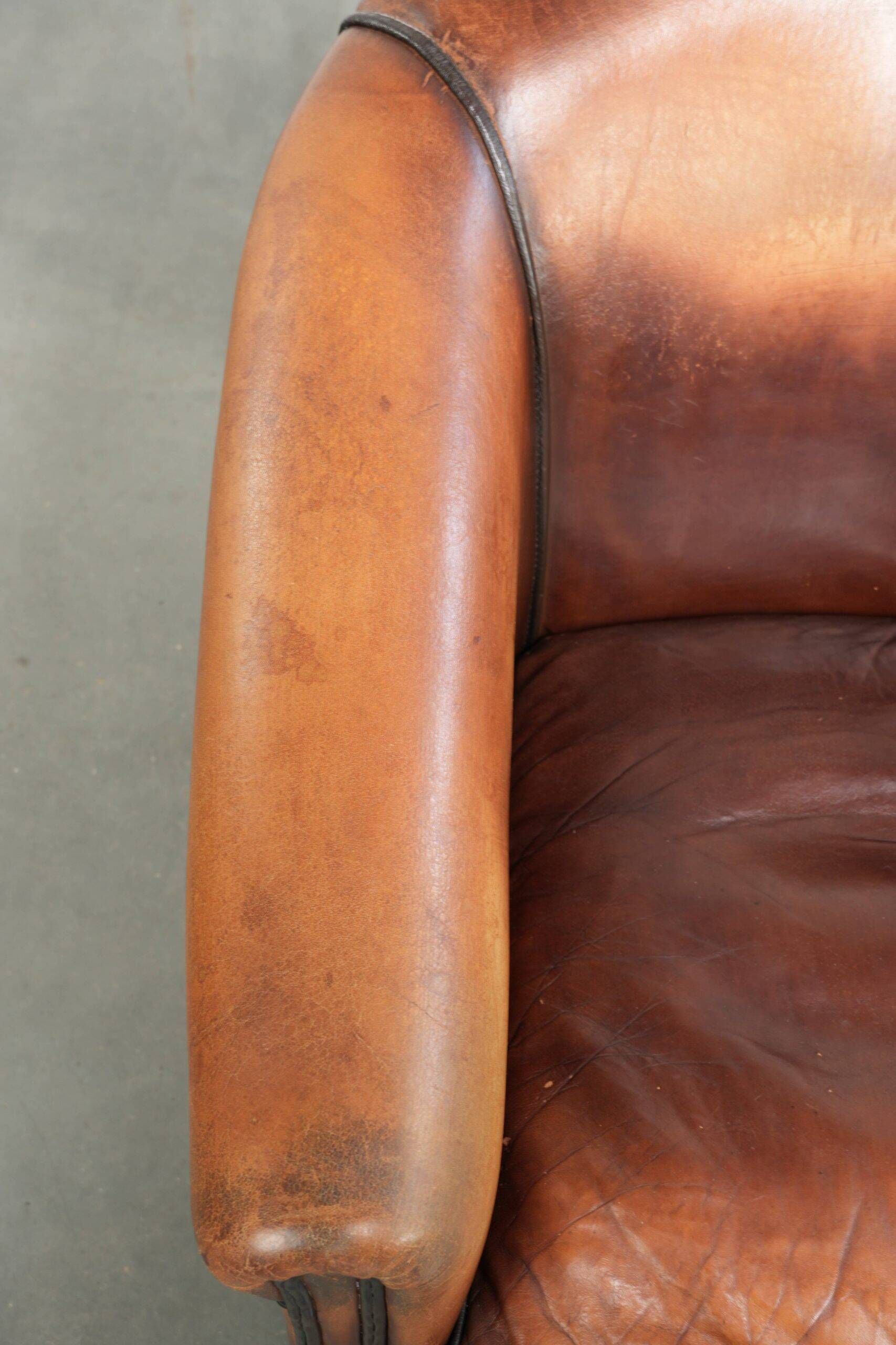 Vintage sheepskin club armchair finished with black piping