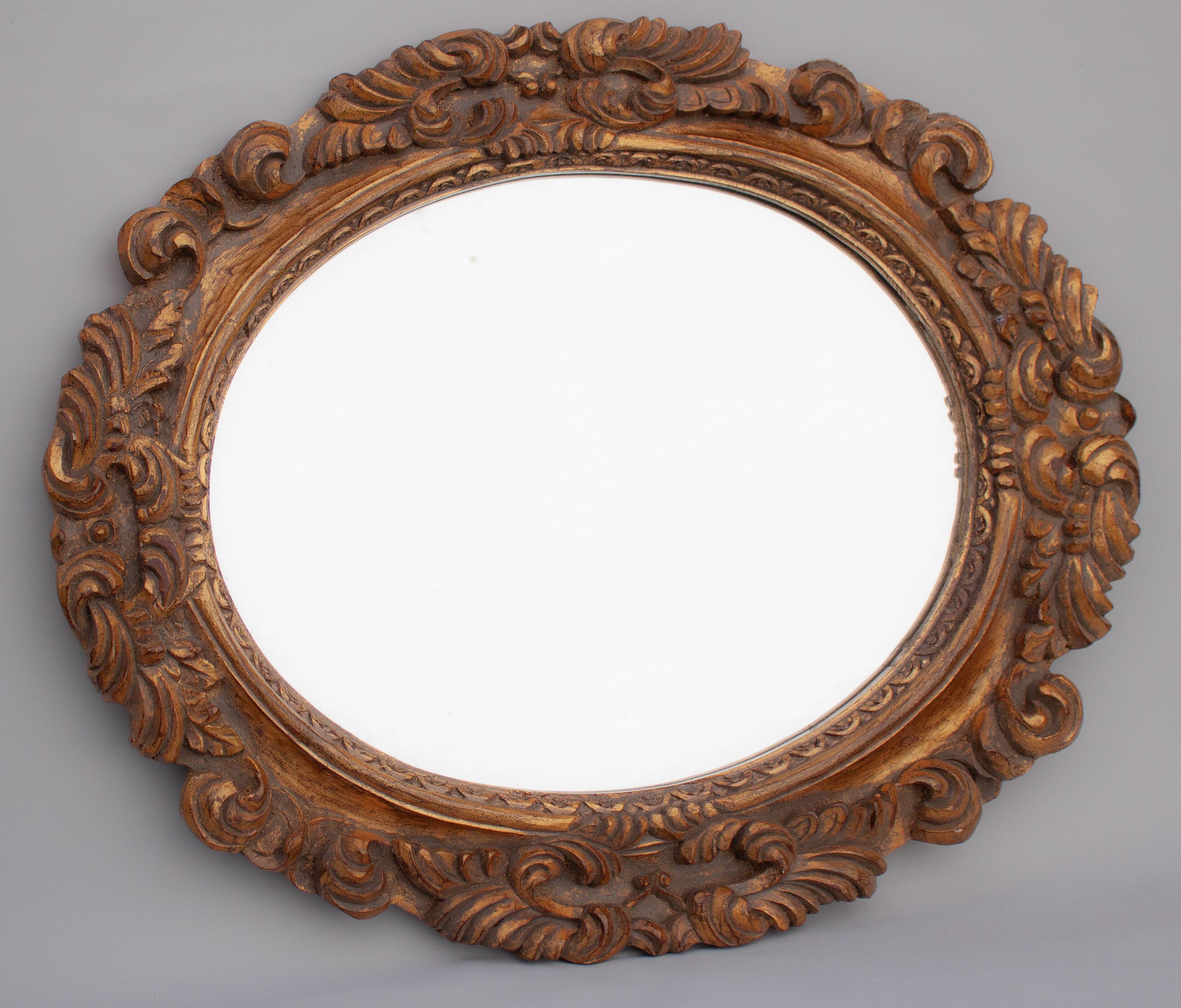 Oval mirror in gilded and carved wood. Vintage mirror. Wall mirror.
