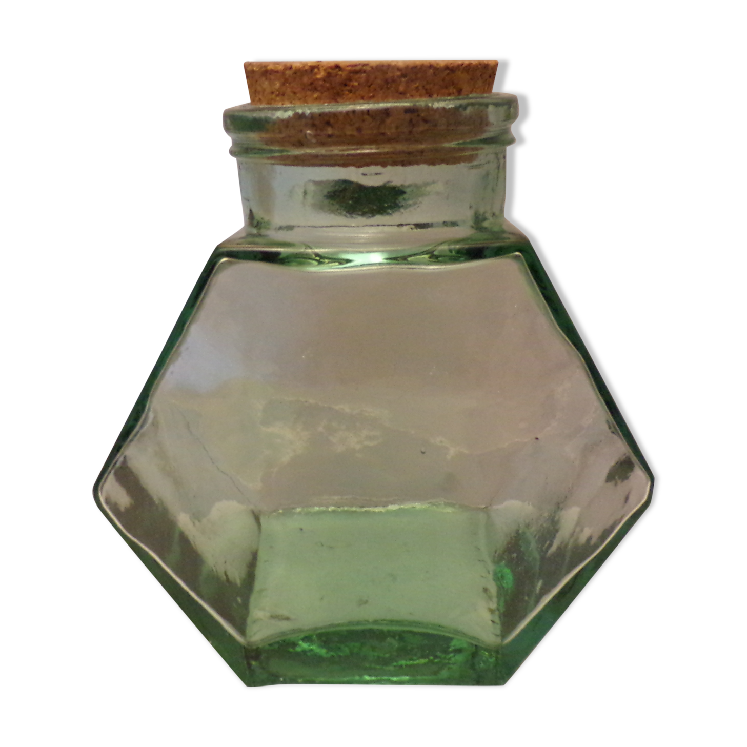 Old thick glass of a light green jar