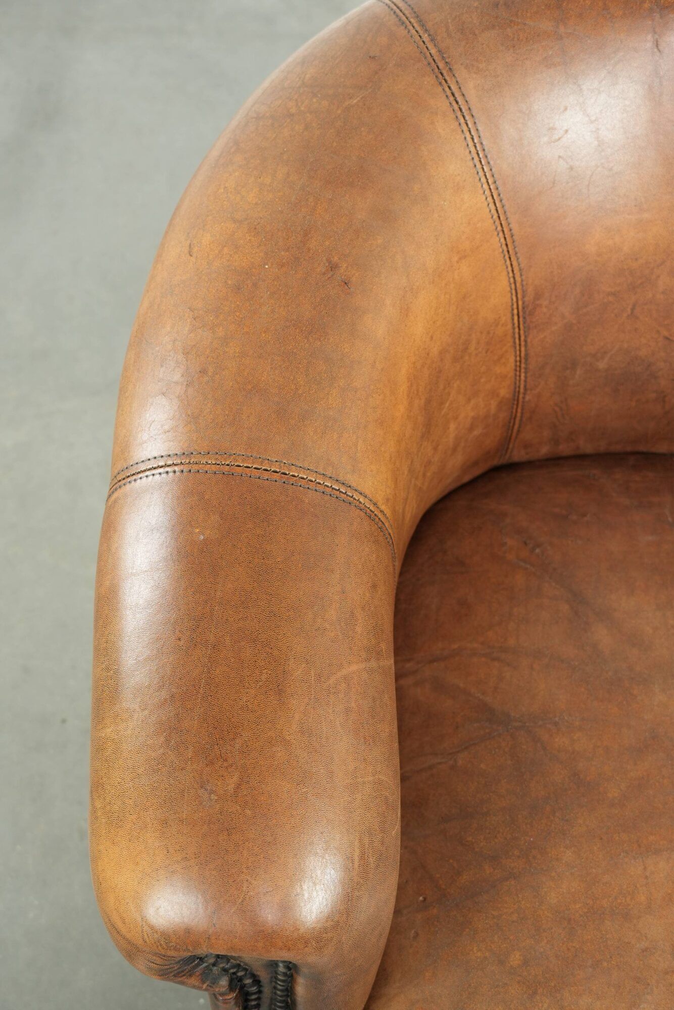 Sheepskin club armchair in a brown colour finished with decorative nails