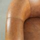 Sheepskin club armchair in a brown colour finished with decorative nails