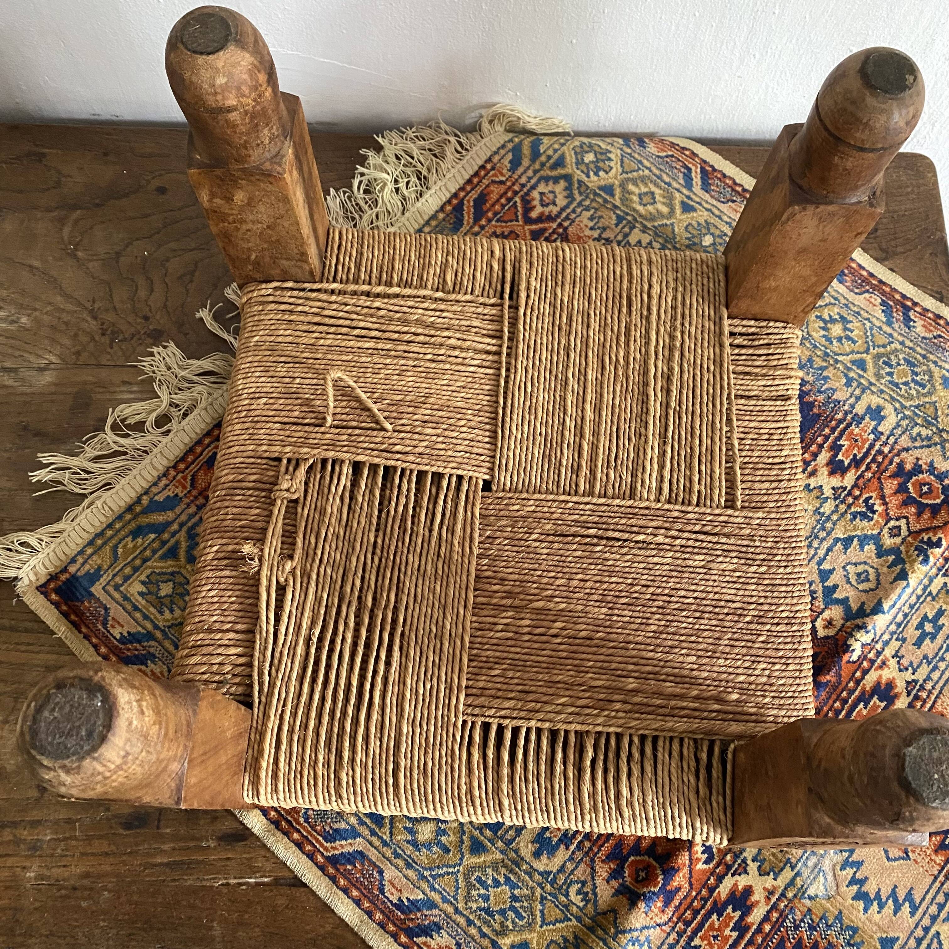 Low stool with carved wood and braided cord.