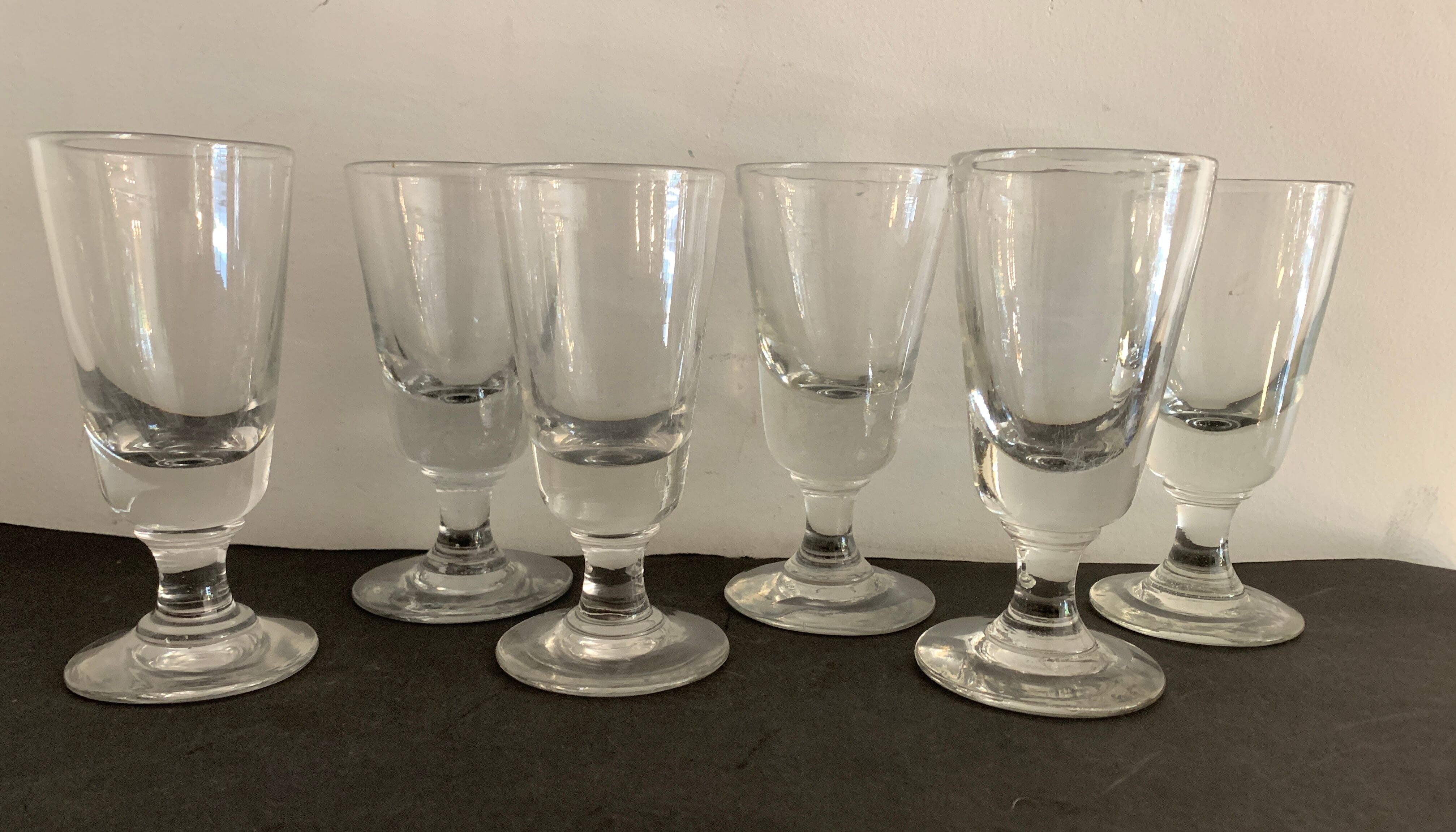 12 old glasses on foot at bistro or absinthe