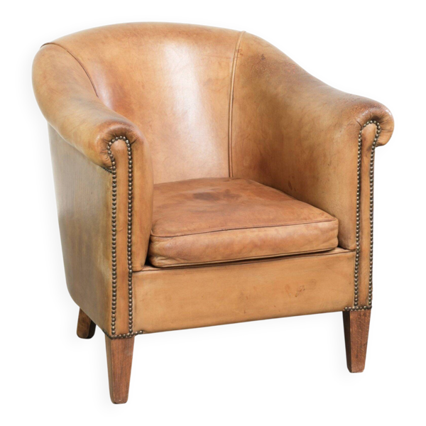 Fauteuil club en peau de mouton confortable de couleur cognac.