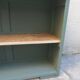 Vintage workshop furniture transformed into a re-enchanted bookshelf in smoky green.