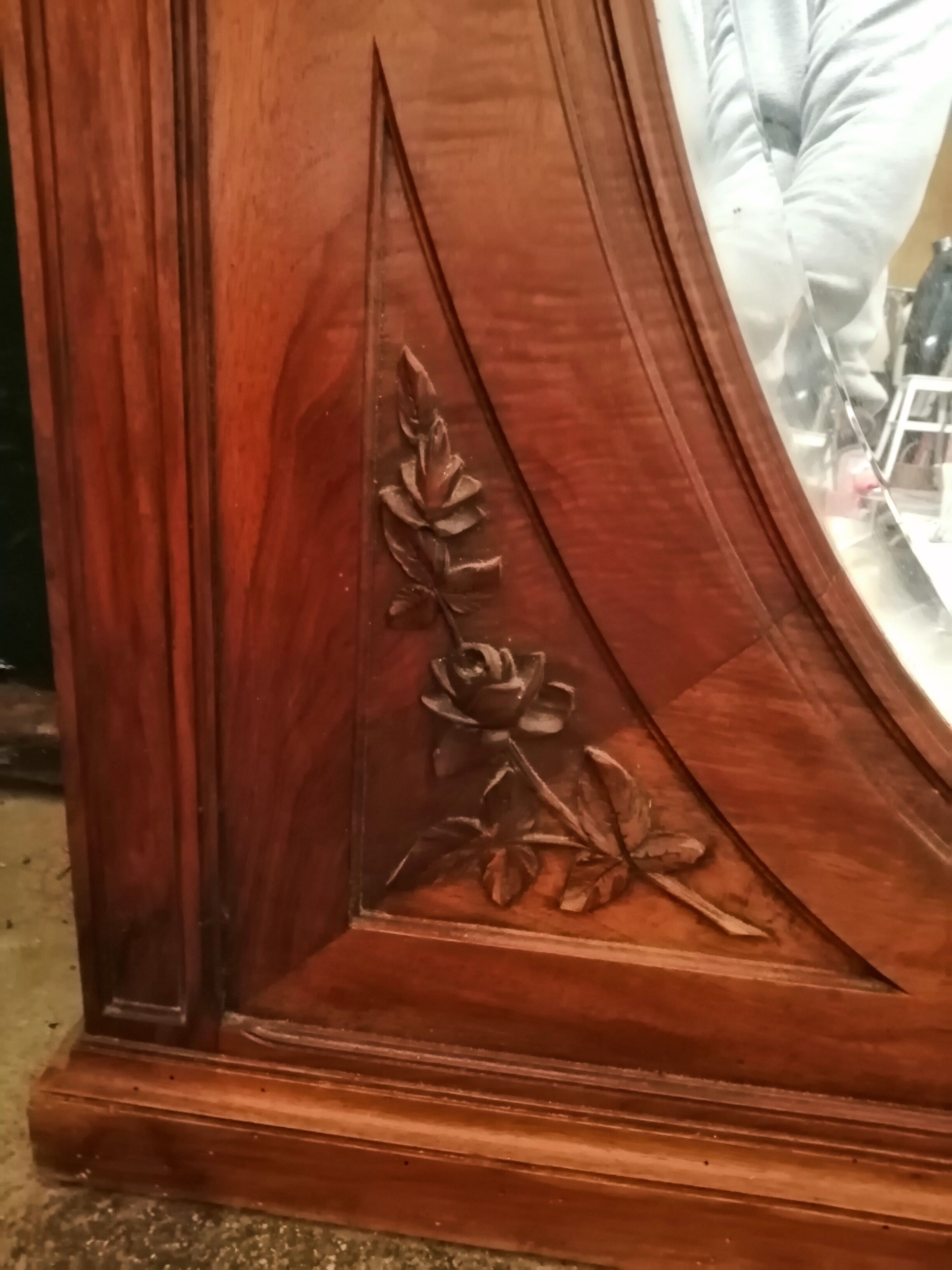 Old oval walnut wood mirror has flower carvings decoration