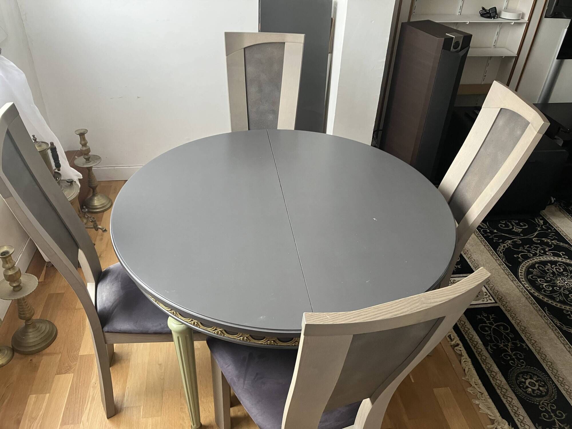 Extendable round table, 2 extensions, and 4 grey velvet chairs.