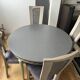 Extendable round table, 2 extensions, and 4 grey velvet chairs.