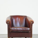 Comfortable, rugged cognac-colored sheepskin club armchair with a characteristic seat cushion