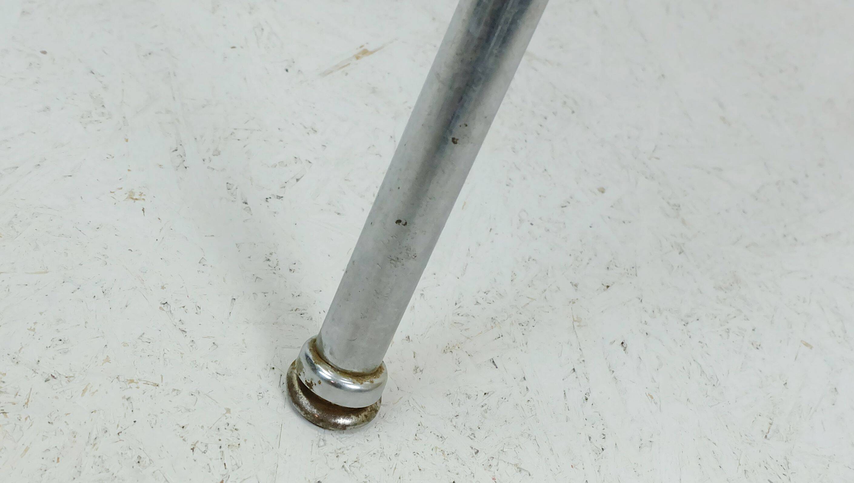 Table basse des années 1950 à trois pieds avec un plateau en formica et des pieds en chrome inclinés.