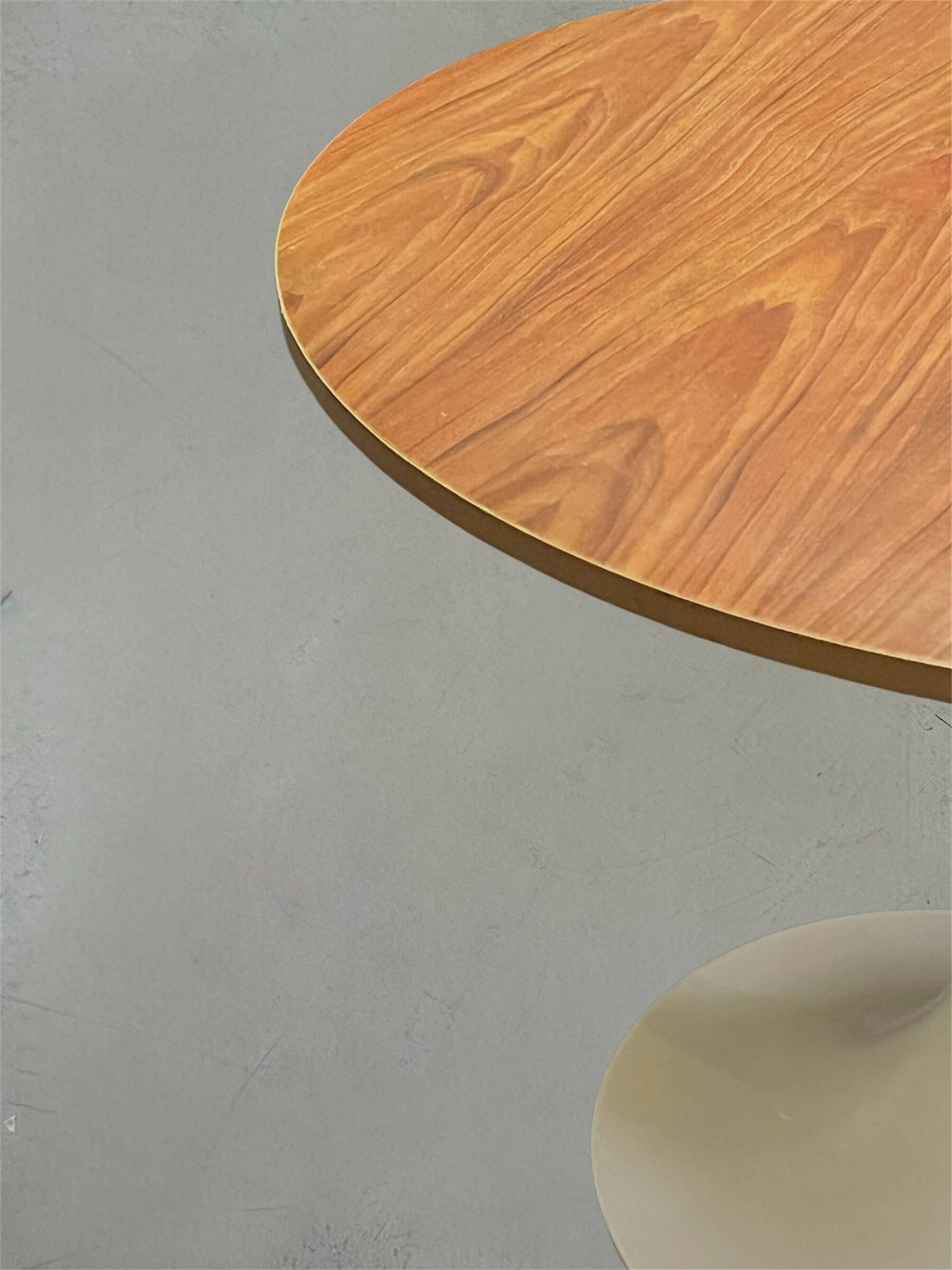 Mid-century round tulip dining table with a wooden top, vintage 1970s design.