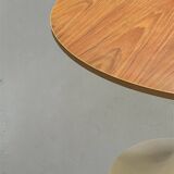Mid-century round tulip dining table with a wooden top, vintage 1970s design.