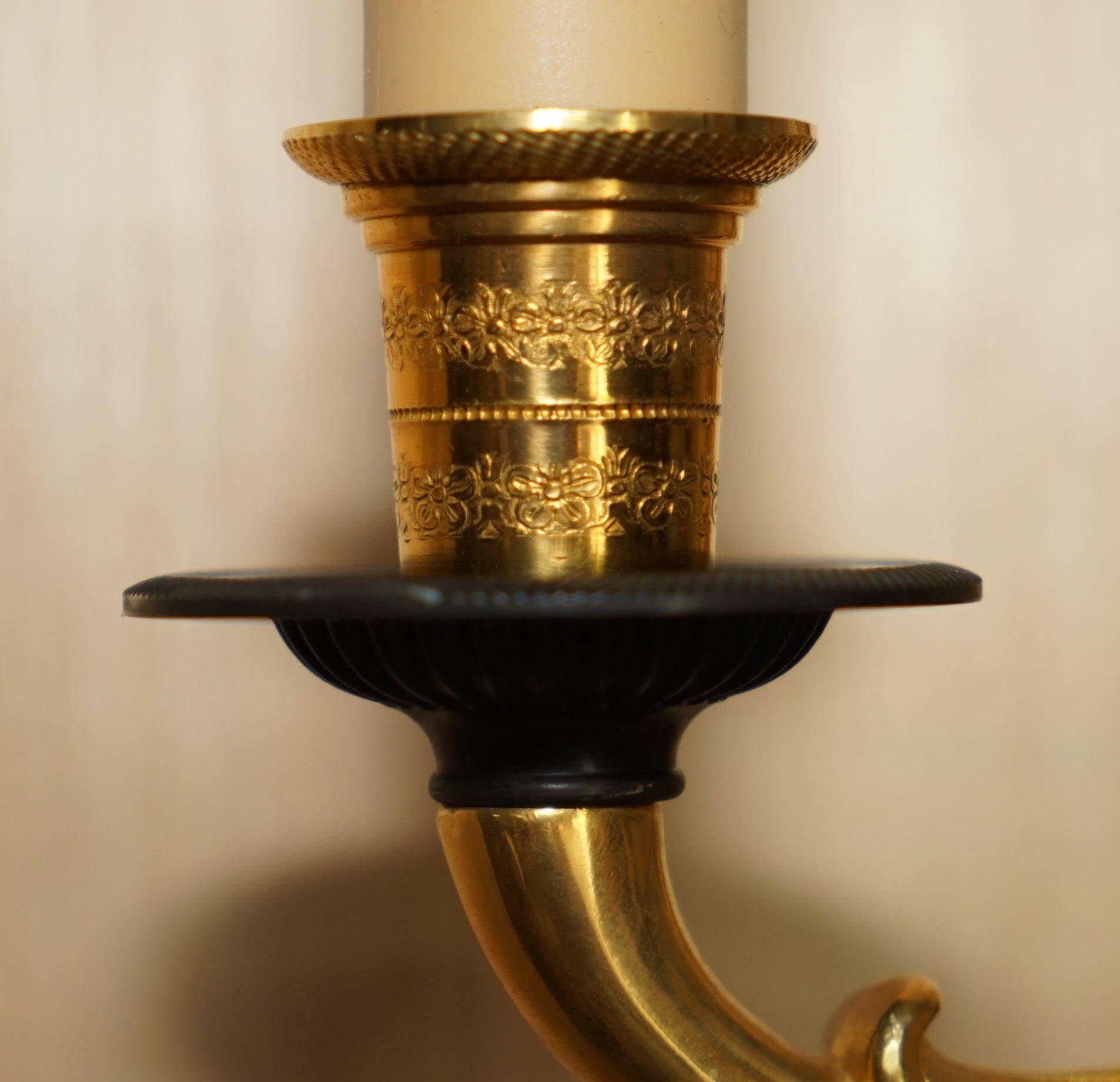 Pair of L'Originale wall sconces plated with 24-carat gold featuring four bronze candles.