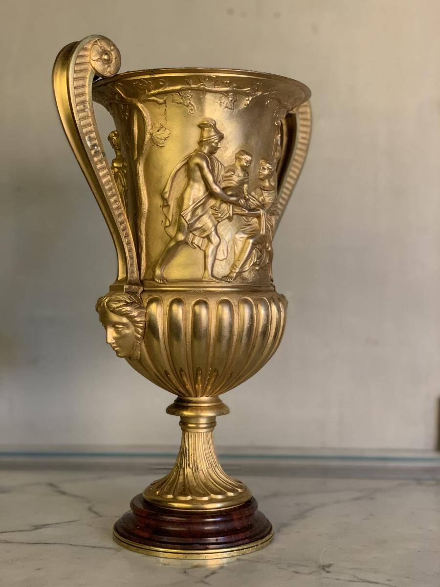Golden bronze urn, base of red griotte marble.
