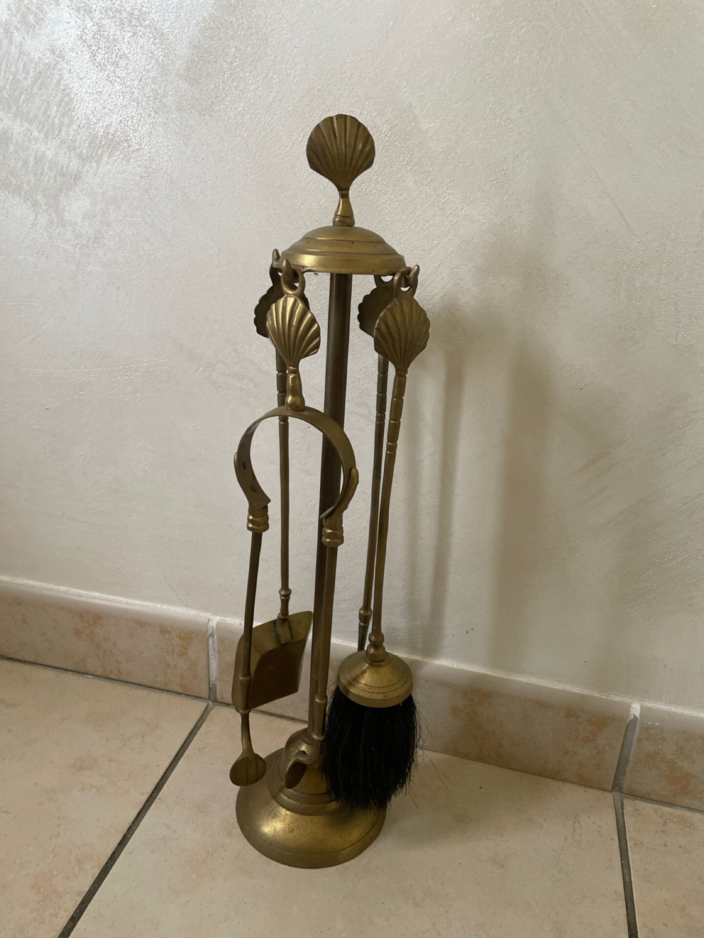 Vintage brass fireplace tool set with shell decoration.