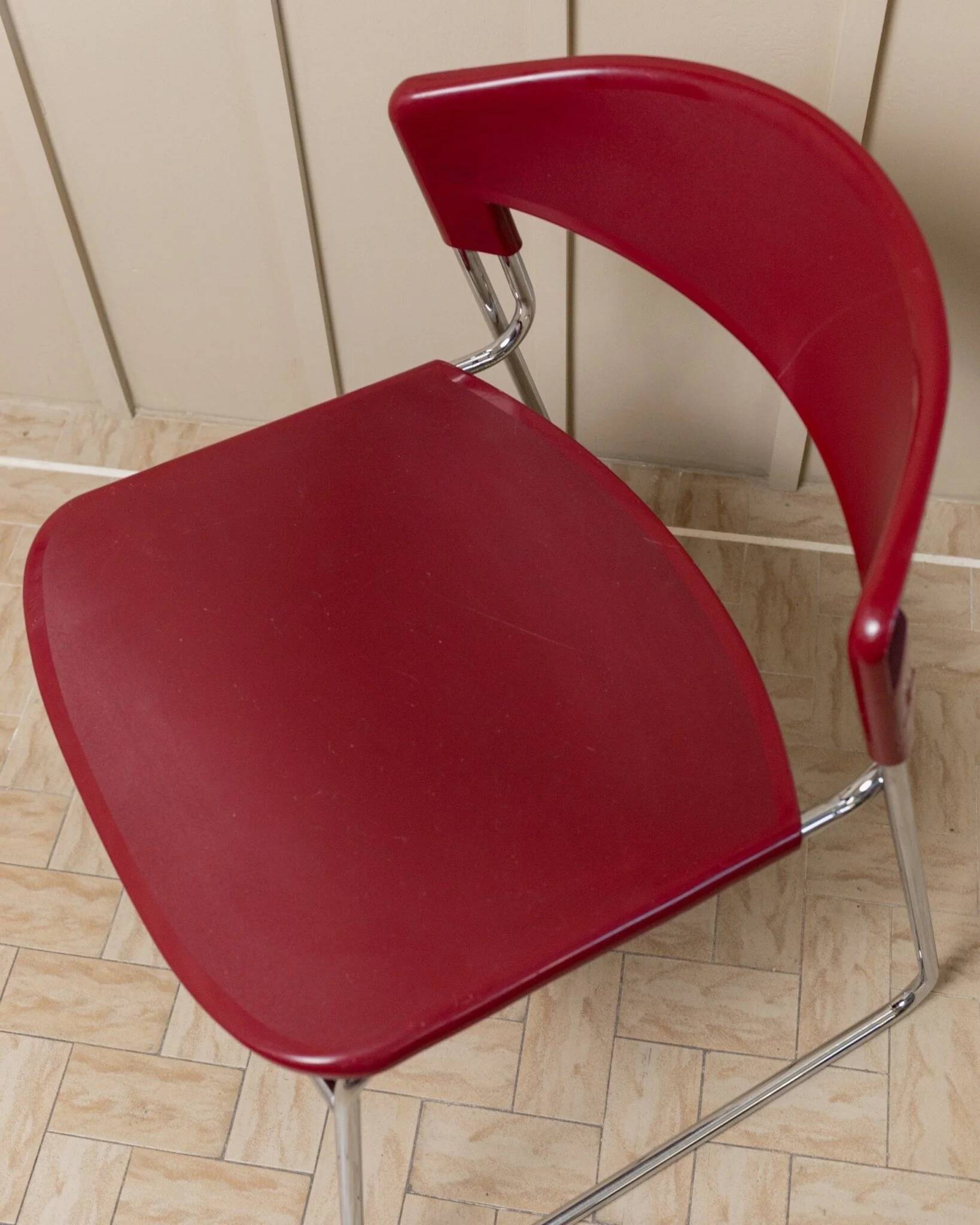 Red plastic-seat stacking chair with chrome frame by Paolo Favaretto for Assisa (Italy 1986) – vintage design