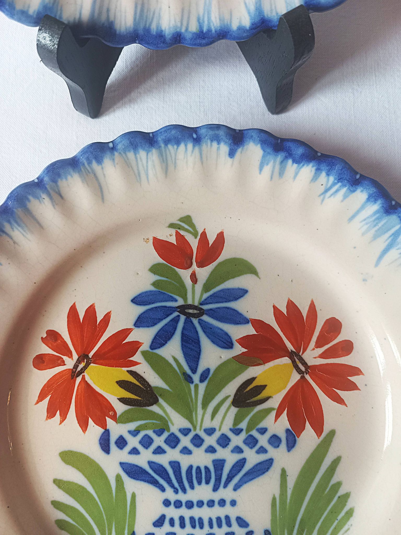 Pair of antique plates in popular earthenware with a floral basket decoration on the edge.