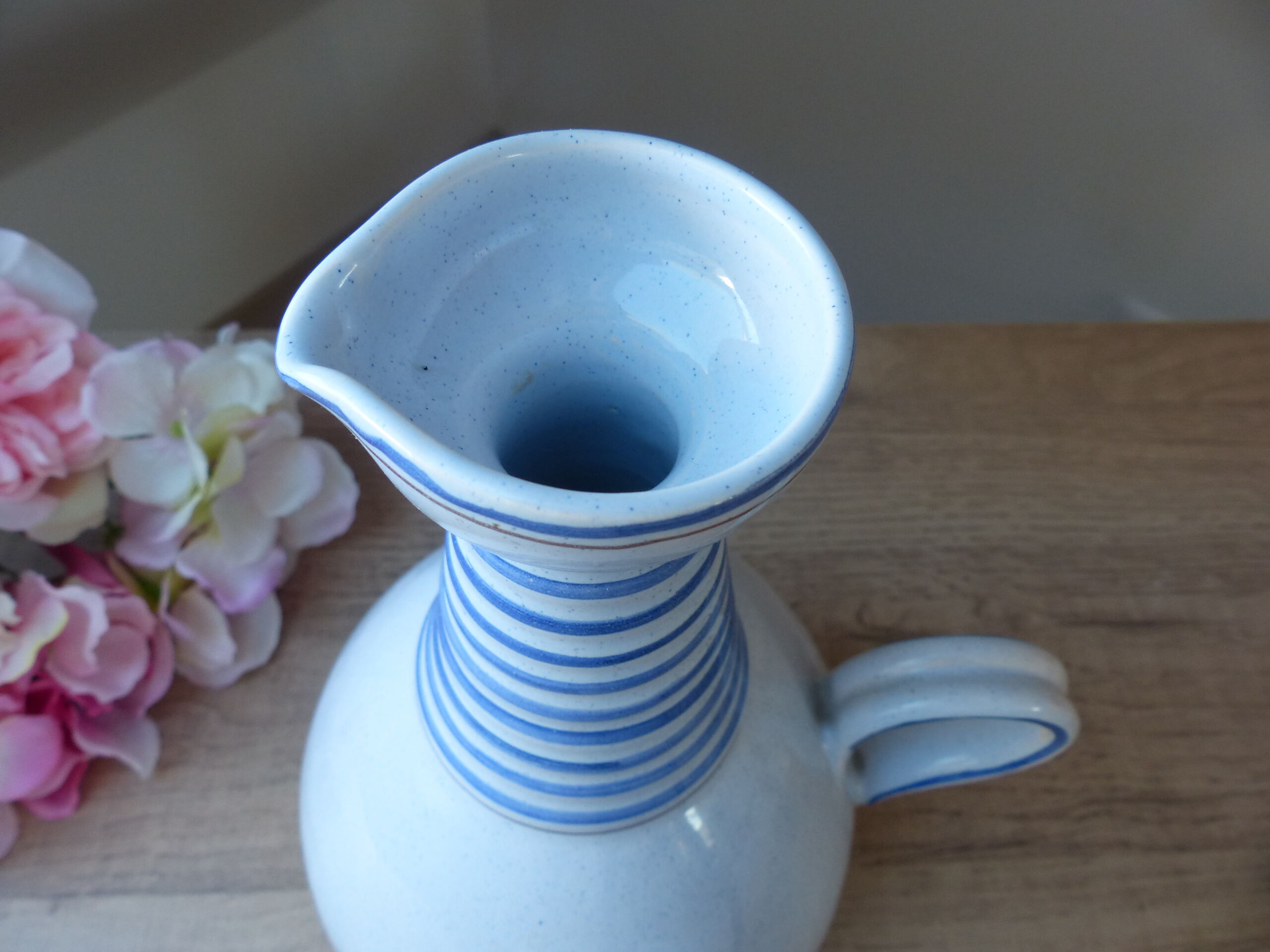 Vintage blue ceramic jug with hand-painted floral decoration.