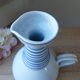 Vintage blue ceramic jug with hand-painted floral decoration.