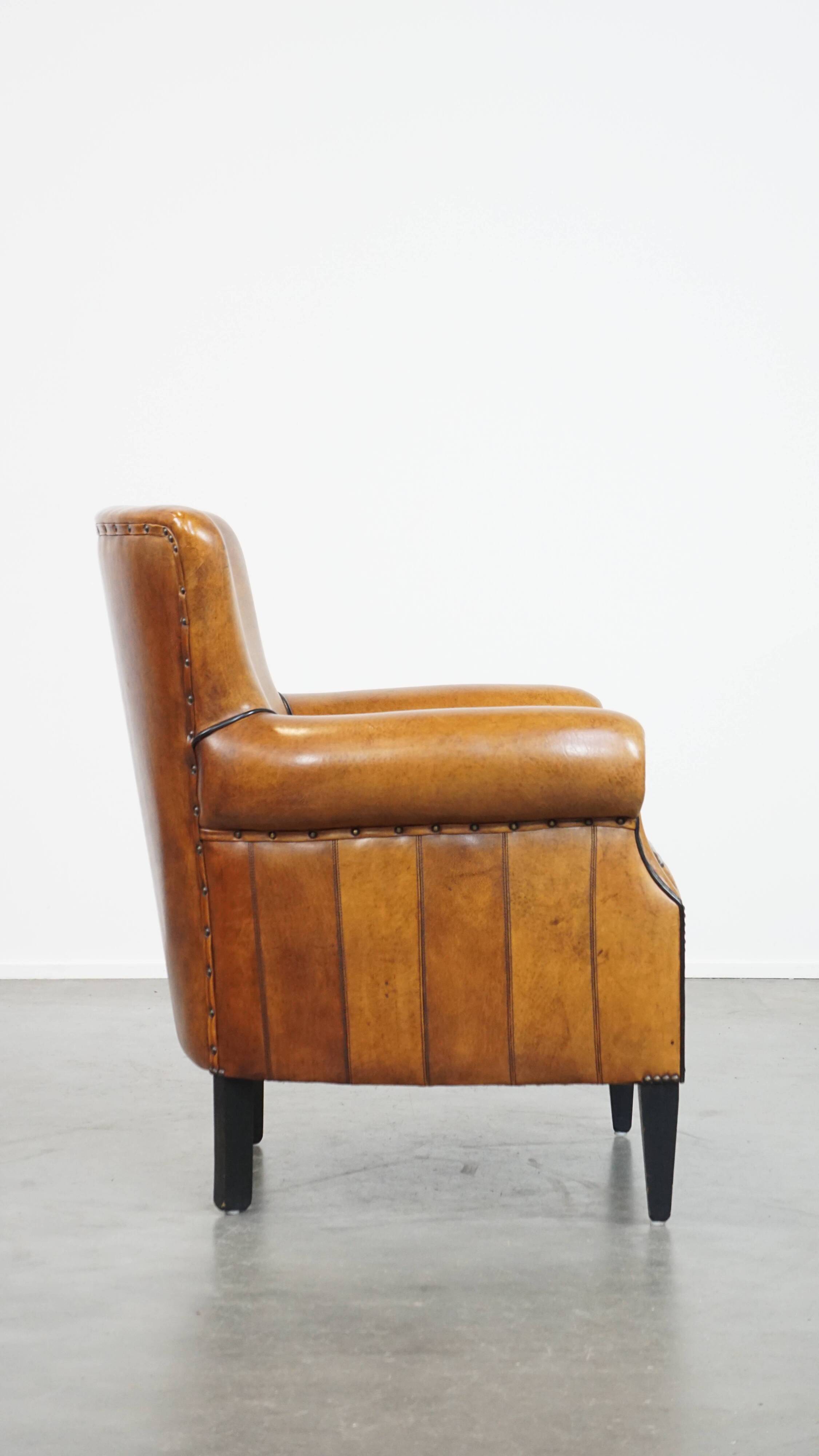Cognac-colored sheep leather armchair finished with decorative nails