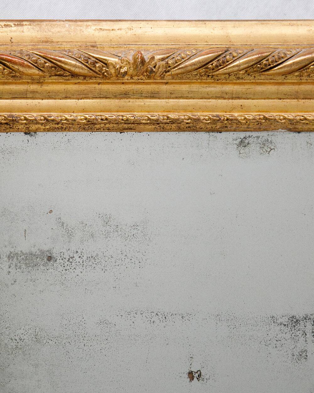 19th-century patinated mirror with a ribbon-style frame