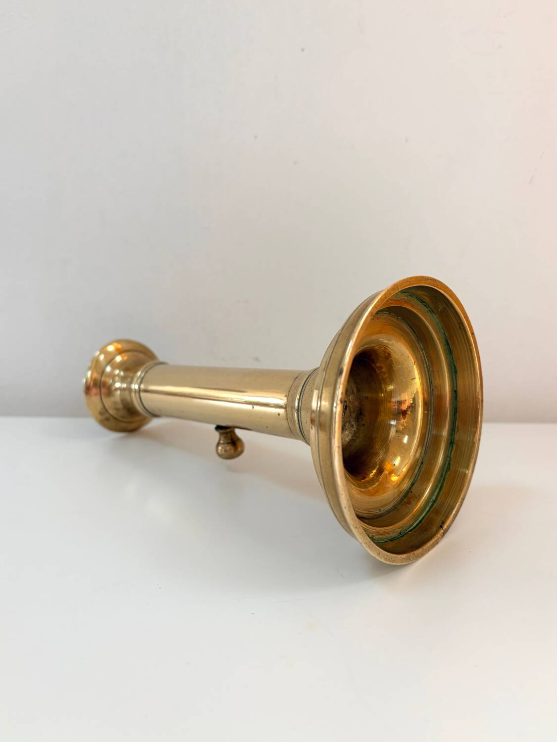 Old brass candlestick with push button.