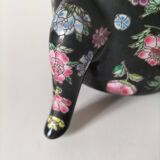 Vintage Chinese teapot with floral polychrome decoration on a black background.