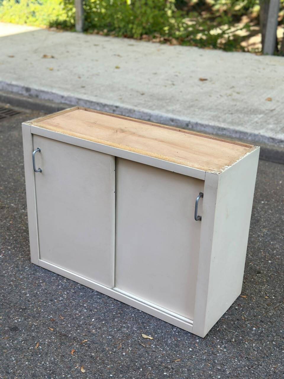 Vintage wall-mounted kitchen cabinet with sliding doors in 1960s retro style.