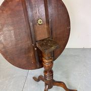 Round coffee table with an adjustable top in antique mahogany.