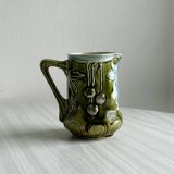 Green slip milk jug with floral patterns.