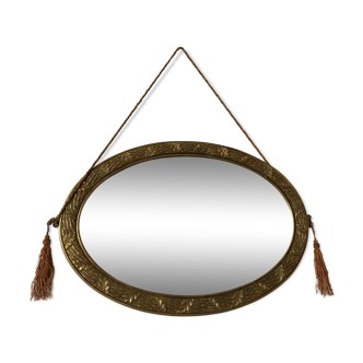 Golden oval mirror with its wooden frame and stucco on wood, nicely cracked by time