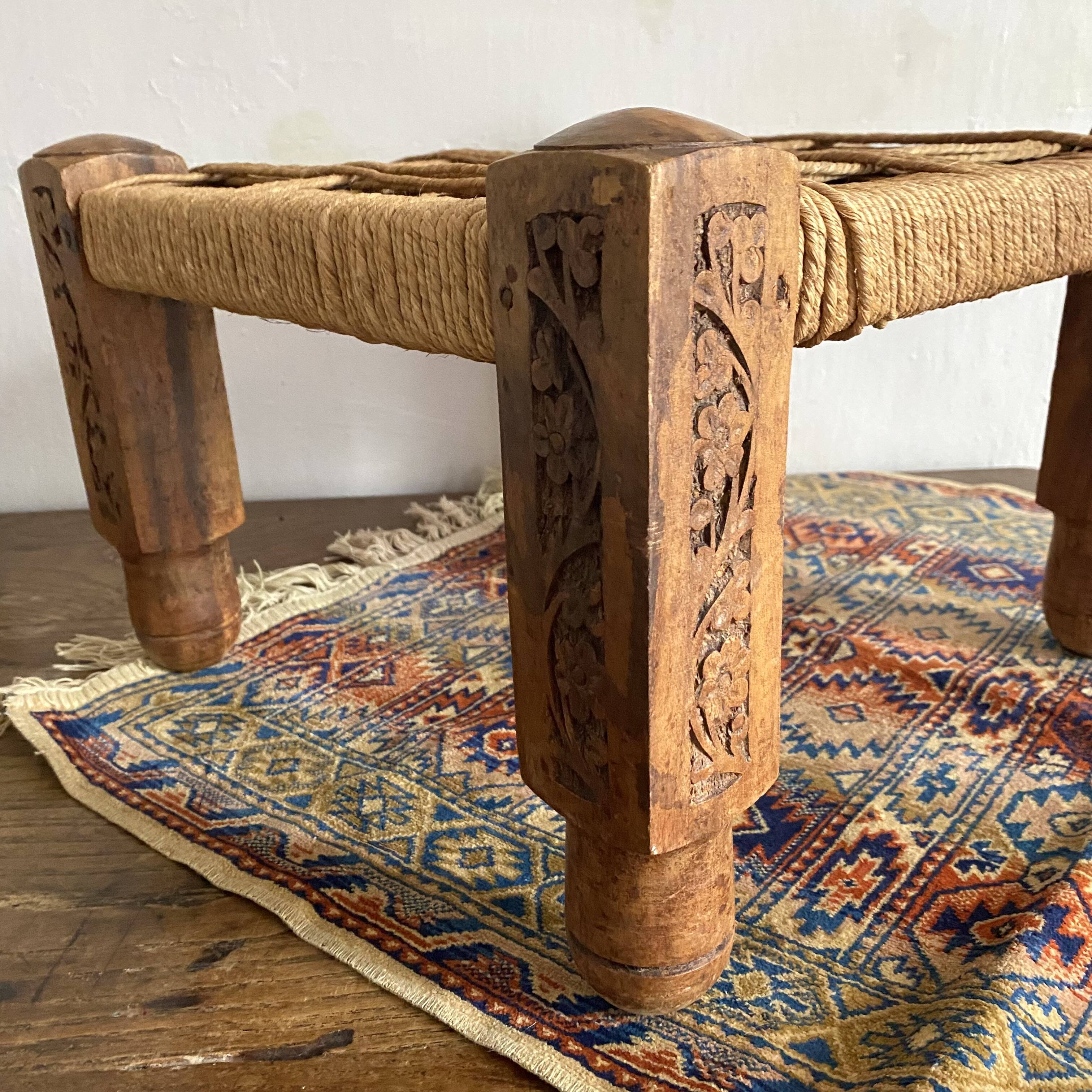 Low stool with carved wood and braided cord.
