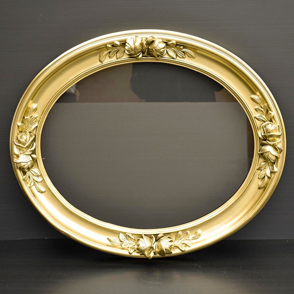 Delightful empty old gilded oval frame with carved wood and stucco flowers 63 x 53
