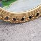Round neoclassical style mirror in wood and gilded stucco from the 1950s