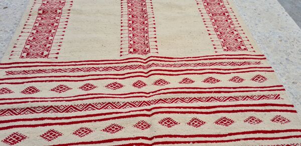 Tapis rouge et blanc à motifs éthniques traditionnel