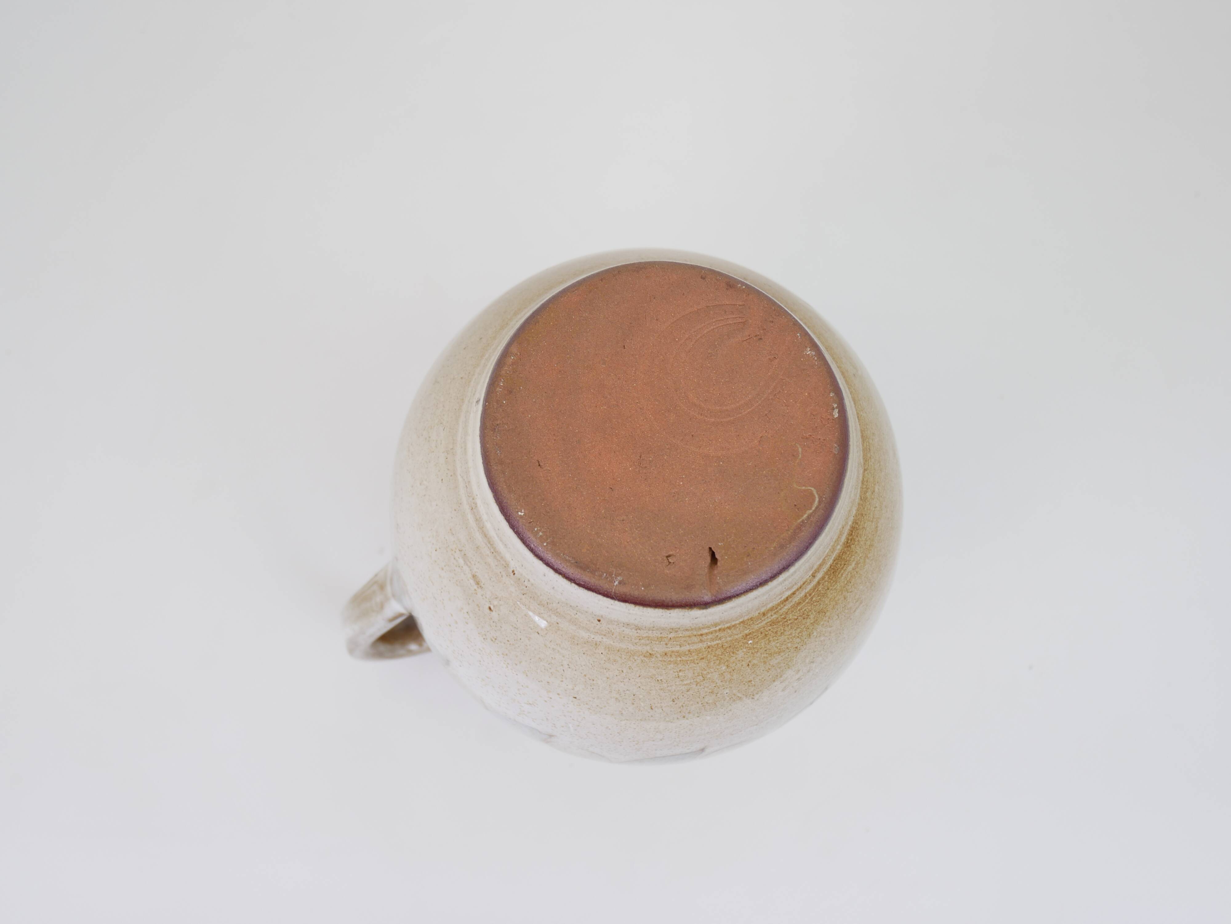 Glazed ceramic jug with plant decoration