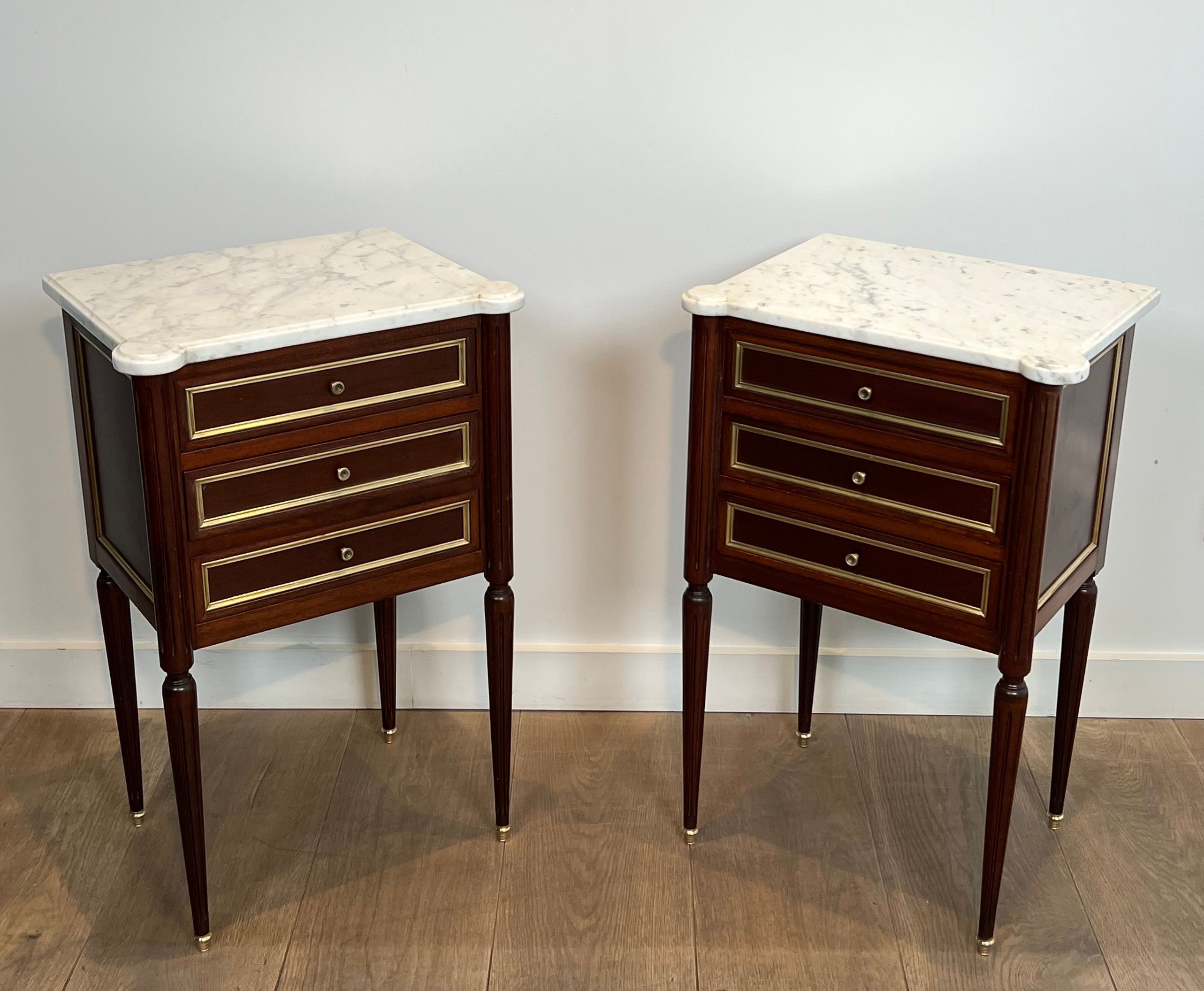 Pair of mahogany and brass side tables or bedside tables with Carrara marble tops.