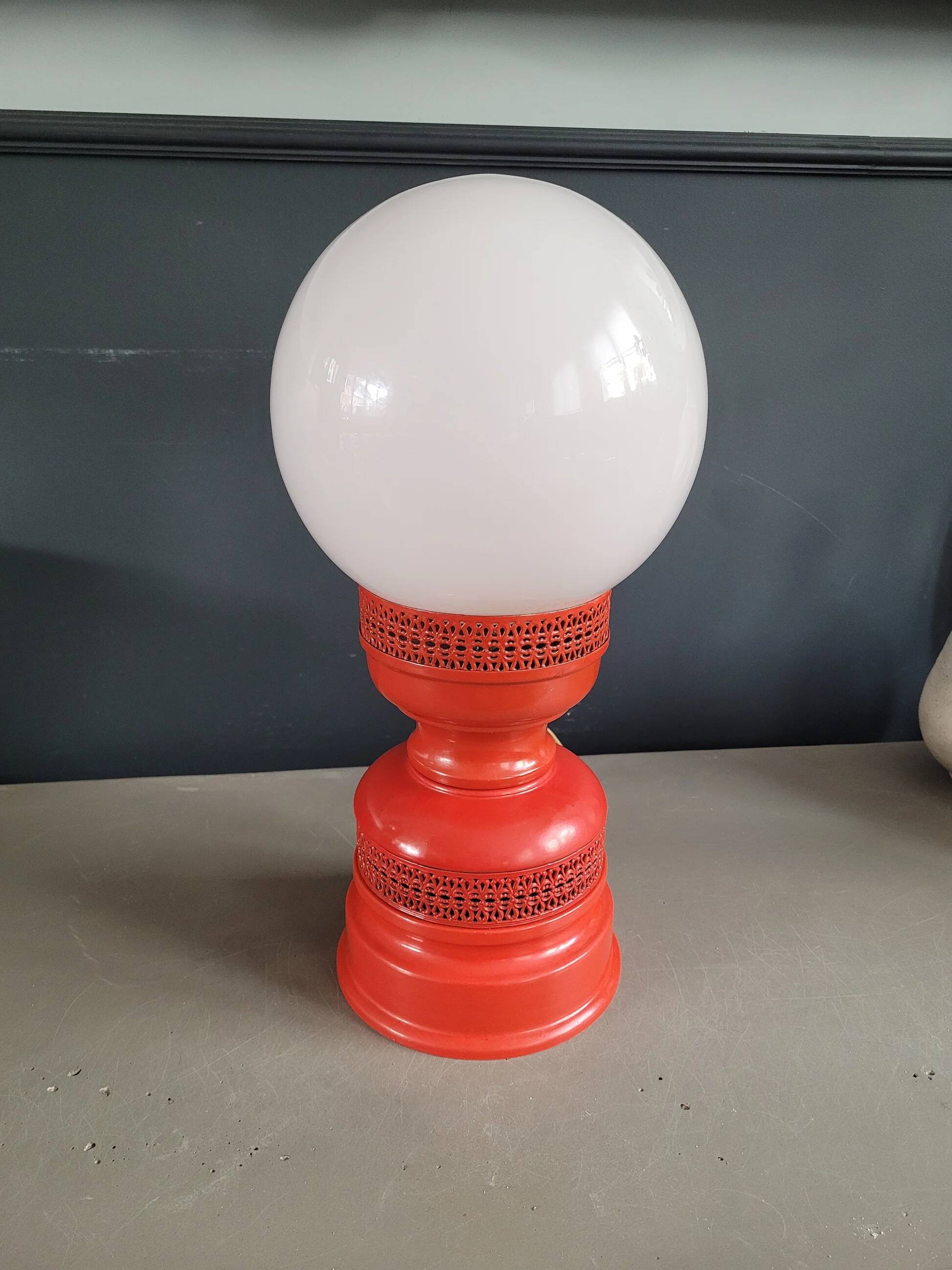 Vintage globe lamp with a metal base, perforated and lacquered in red.