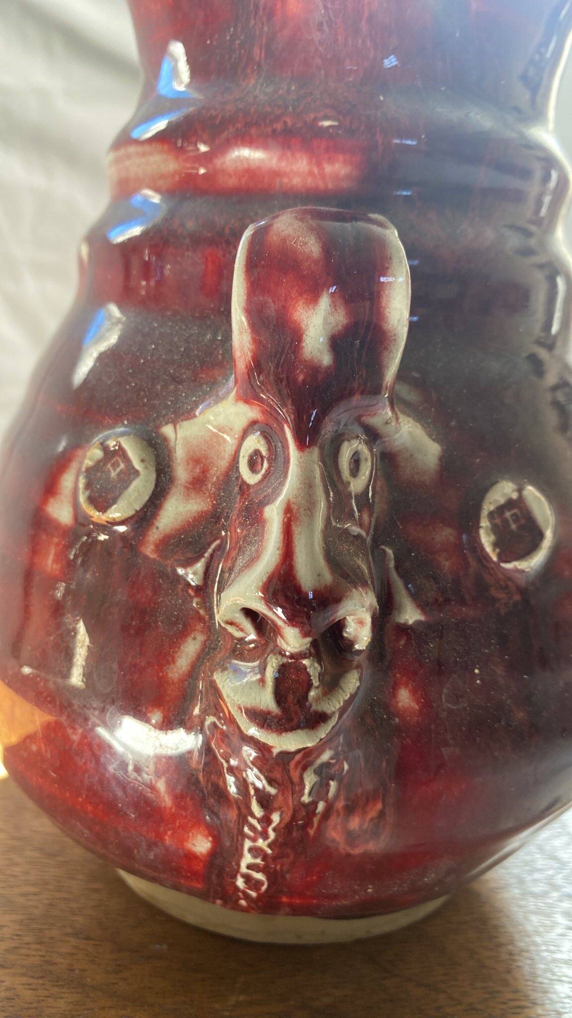Oxblood pitcher with grotesque mask in the Delplera spirit