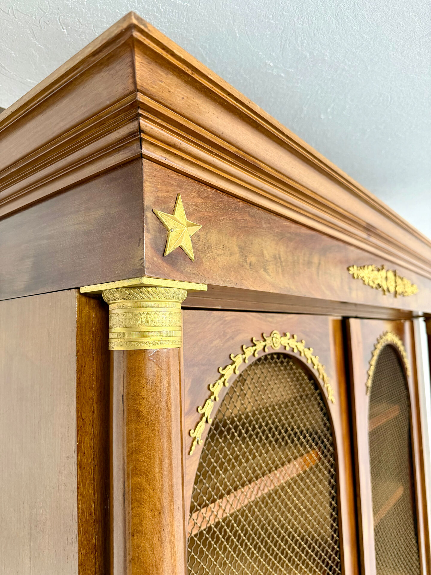Large Empire-style library in wood with gilded bronze ornaments.
