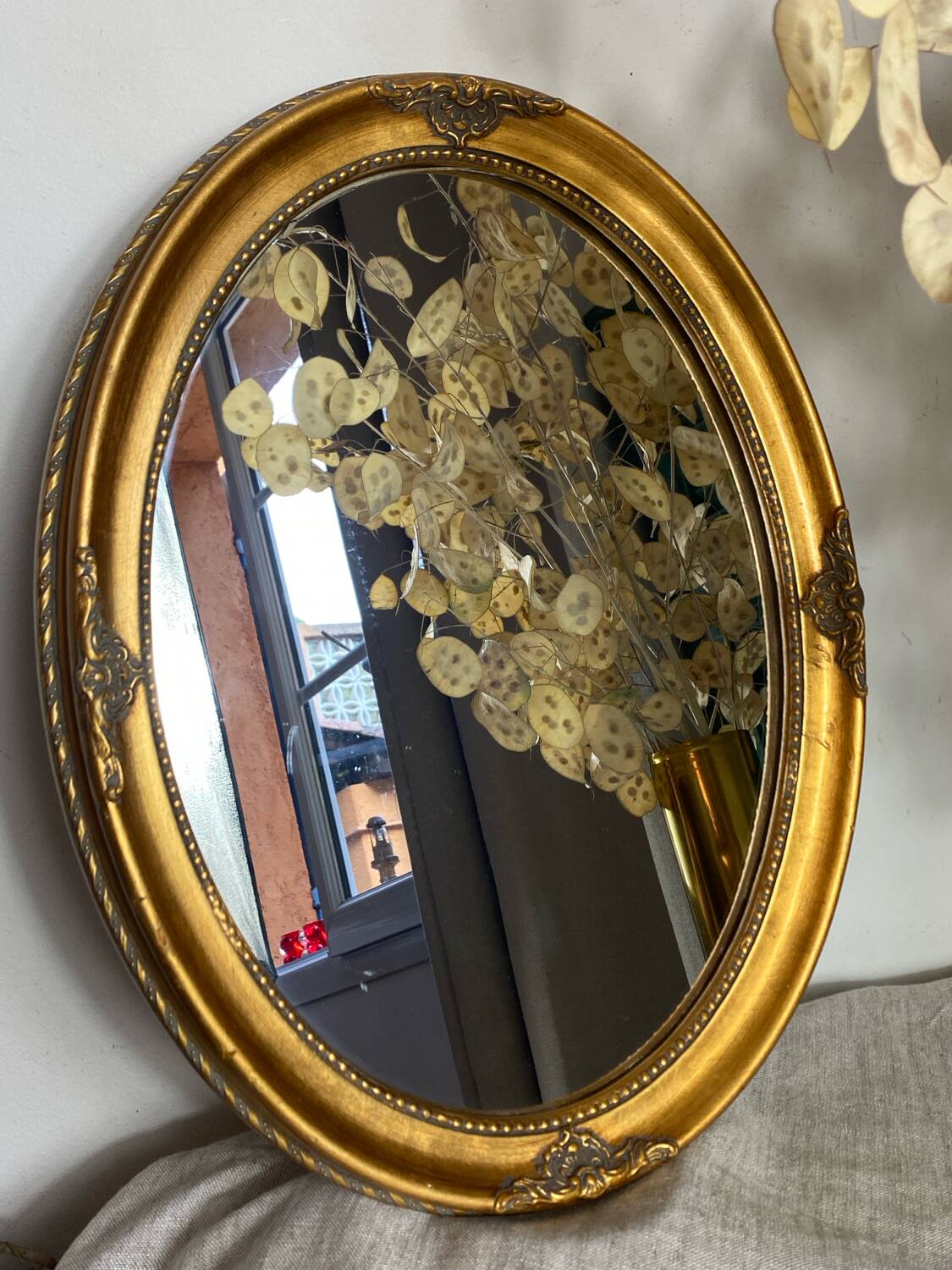 Oval-shaped gilded wooden mirror