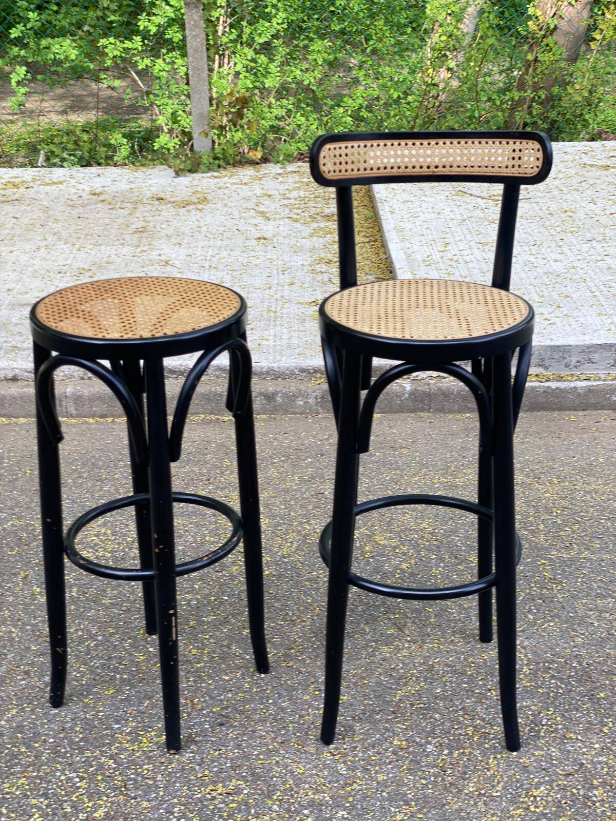 High bistro bar stool in curved black wood with a cane backrest.