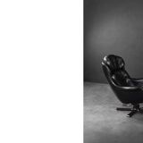 Vintage black leather swivel chair in mid-century modern Scandinavian style.