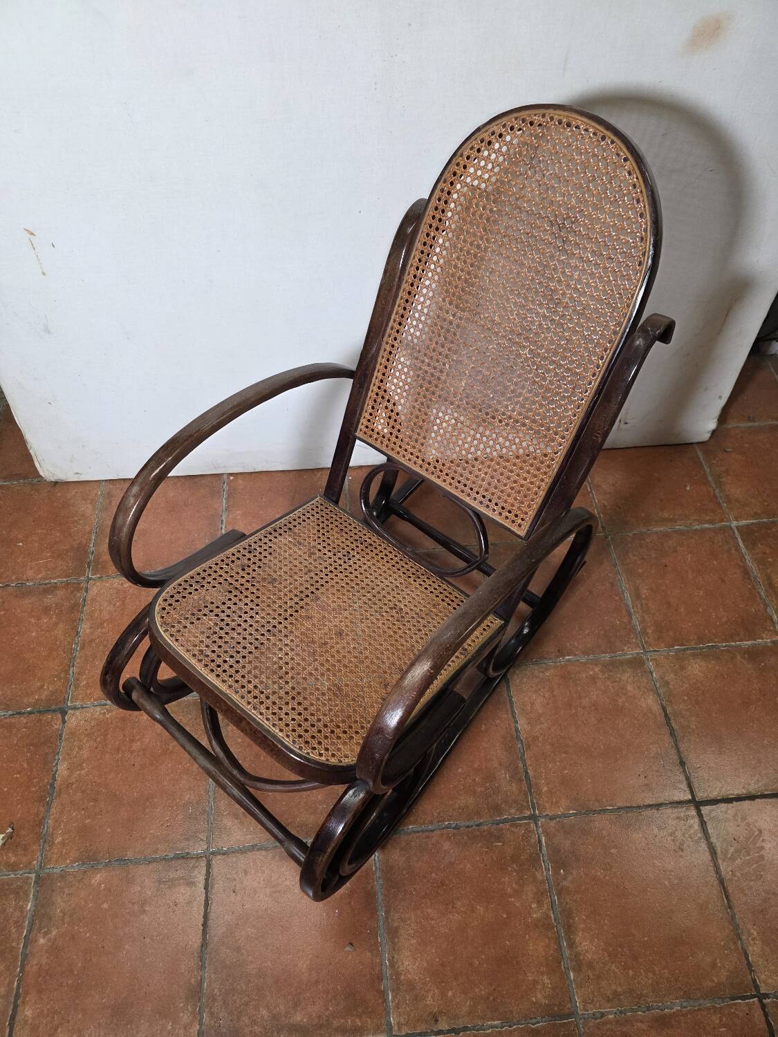 Curved wooden rocking chair with caning