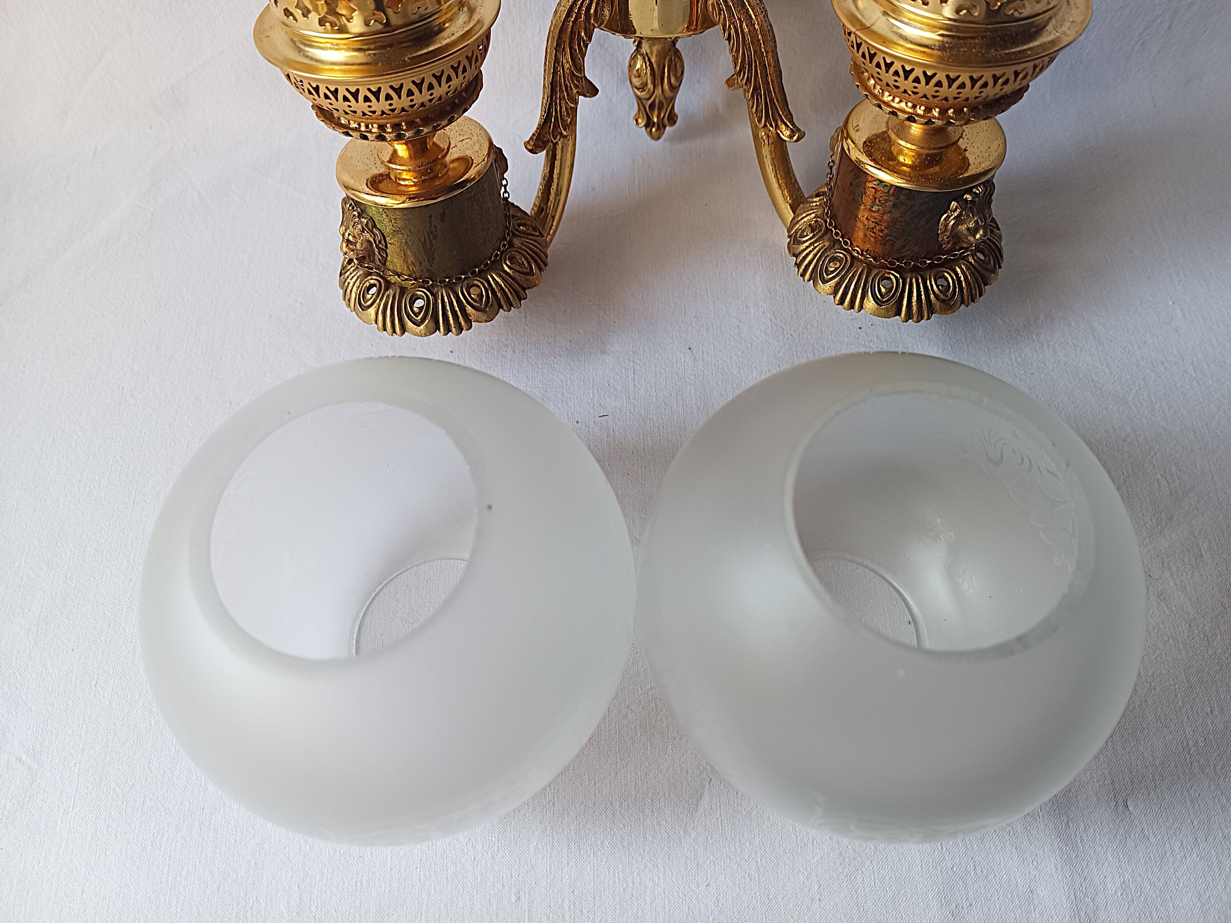 Wall lamp in gilded bronze with a lion's head and engraved globe.