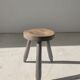 Small brutalistic tripod stool in dark wood tapered feet circular seat