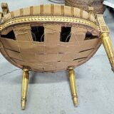 A pair of gilded wooden armchairs in the Louis XVI style.